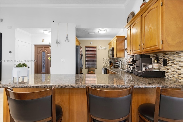 19251 SW 118th Ct, Miami, FL 33177 - kitchen with appliances with stainless steel finishes, decorative backsplash, dark stone counters, a peninsula, and crown molding