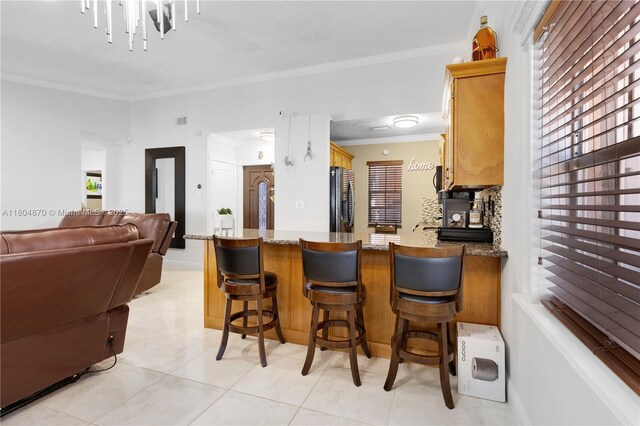 19251 SW 118th Ct, Miami, FL 33177 - kitchen featuring freestanding refrigerator, crown molding, open floor plan, a peninsula, and stone counters