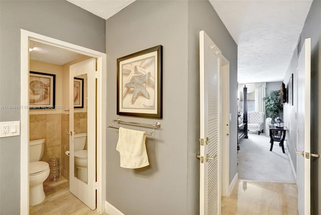 3725 S Ocean Dr Unit 1014, Hollywood, FL 33019 - bathroom with toilet, tile walls, and a textured ceiling