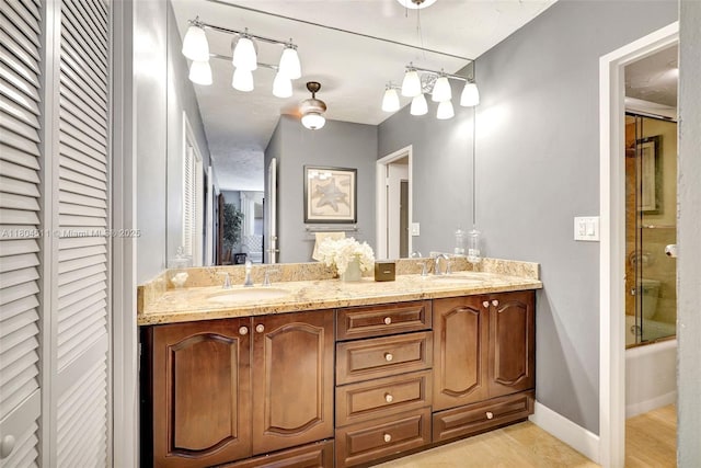 3725 S Ocean Dr Unit 1014, Hollywood, FL 33019 - bathroom featuring double vanity, a closet, enclosed tub / shower combo, and baseboards