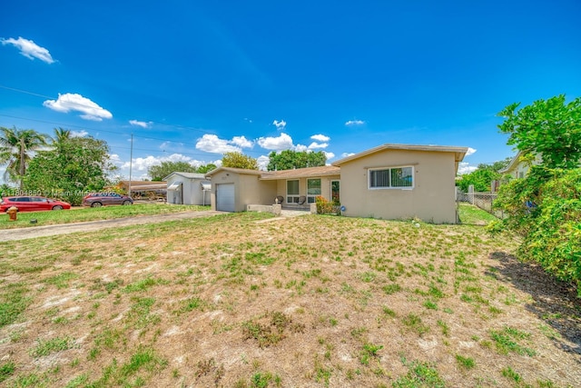 7717 Coral Blvd, Miramar, FL 33023 - rear view of house featuring stucco siding, a garage, and driveway