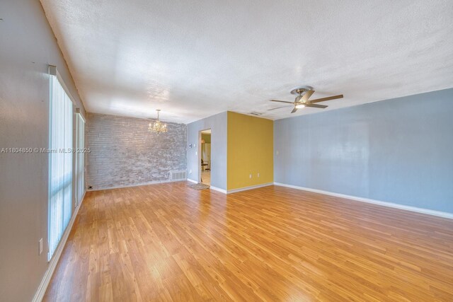 7717 Coral Blvd, Miramar, FL 33023 - spare room featuring a chandelier, light wood-style floors, a textured ceiling, ceiling fan, and baseboards