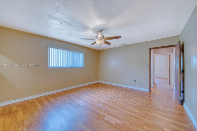 7717 Coral Blvd, Miramar, FL 33023 - empty room with light wood-type flooring, a ceiling fan, baseboards, and a textured ceiling