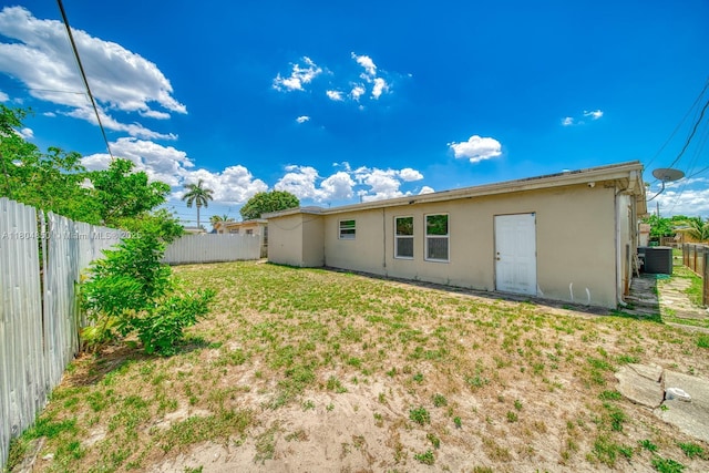 7717 Coral Blvd, Miramar, FL 33023 - rear view of house with stucco siding, a fenced backyard, and cooling unit