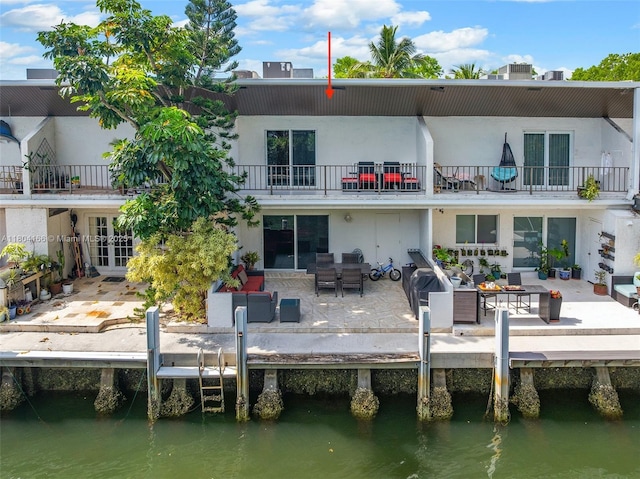3553 NE 171st St Unit P, North Miami Beach, FL 33160 - rear view of house featuring a balcony, french doors, a water view, stucco siding, and an outdoor hangout area