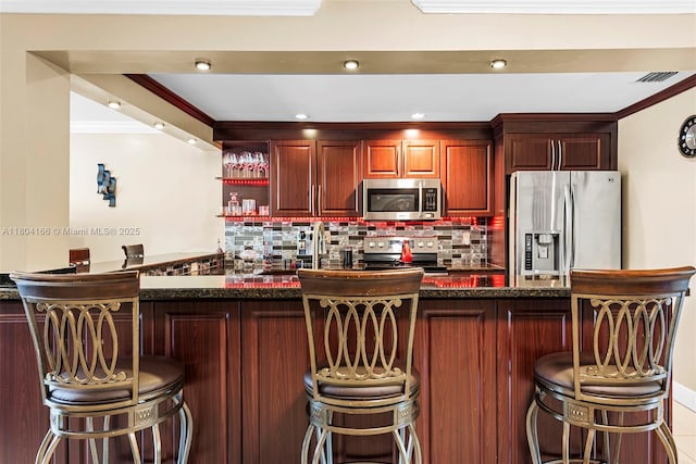 3553 NE 171st St Unit P, North Miami Beach, FL 33160 - kitchen with stainless steel appliances, ornamental molding, backsplash, a sink, and a kitchen bar