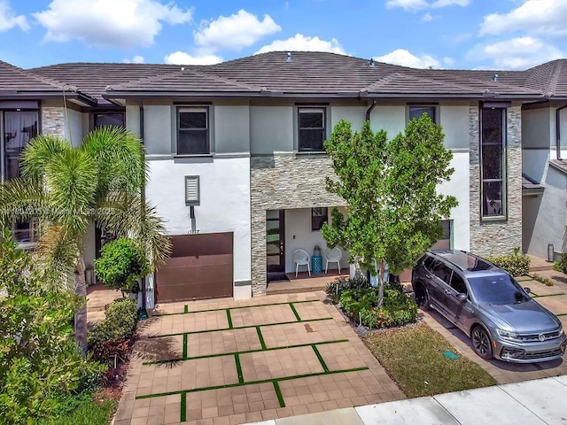 15678 NW 91st Ct, Miami Lakes, FL 33018 - view of front of property with stone siding, stucco siding, a tiled roof, and an attached garage