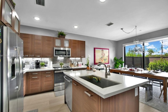 15678 NW 91st Ct, Miami Lakes, FL 33018 - kitchen with appliances with stainless steel finishes, a sink, light countertops, an island with sink, and glass insert cabinets