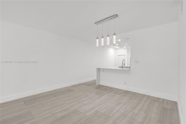 3401 Bimini Ln Unit E1, Coconut Creek, FL 33066 - empty room featuring baseboards, a sink, and light wood-style flooring