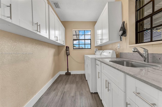 10350 SW 30th St, Miami, FL 33165 - laundry room with cabinet space, washer and dryer, wood finished floors, baseboards, and a textured wall