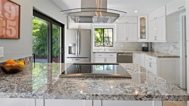 4955 NW 10th St, Coconut Creek, FL 33063 - kitchen featuring stainless steel appliances, island range hood, tasteful backsplash, glass insert cabinets, and white cabinetry