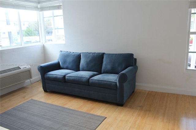 300 74th St Unit 10, Miami Beach, FL 33141 - living room with healthy amount of natural light, a wall mounted AC, baseboards, and wood finished floors