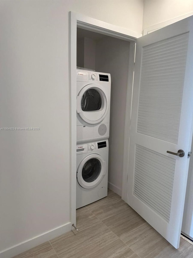 580 72 Unit Ph7, Miami Beach, FL 33141 - clothes washing area featuring stacked washer / drying machine, light wood finished floors, and baseboards