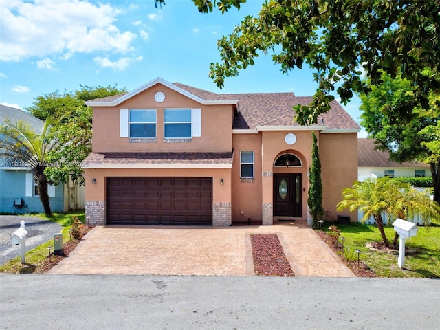 10920 SW 11th Ct, Davie, FL 33324 - traditional home featuring stucco siding, an attached garage, decorative driveway, and a shingled roof