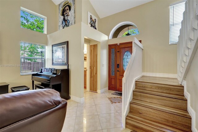 10920 SW 11th Ct, Davie, FL 33324 - foyer entrance with stairway, high vaulted ceiling, baseboards, and light tile patterned floors