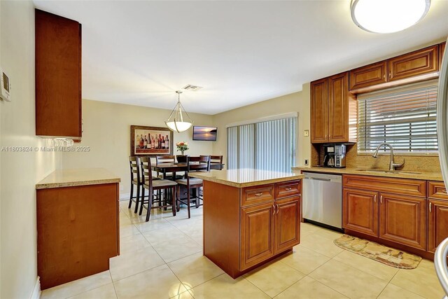 10920 SW 11th Ct, Davie, FL 33324 - kitchen featuring stainless steel dishwasher, a sink, pendant lighting, a kitchen island, and light tile patterned floors