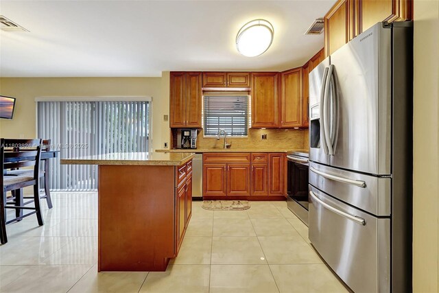 10920 SW 11th Ct, Davie, FL 33324 - kitchen with appliances with stainless steel finishes, a kitchen island, light countertops, backsplash, and a sink