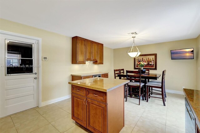 10920 SW 11th Ct, Davie, FL 33324 - kitchen with brown cabinets, light tile patterned flooring, hanging light fixtures, baseboards, and a center island