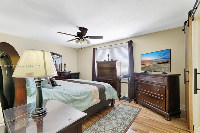 10920 SW 11th Ct, Davie, FL 33324 - bedroom featuring light wood-style flooring, a barn door, and ceiling fan