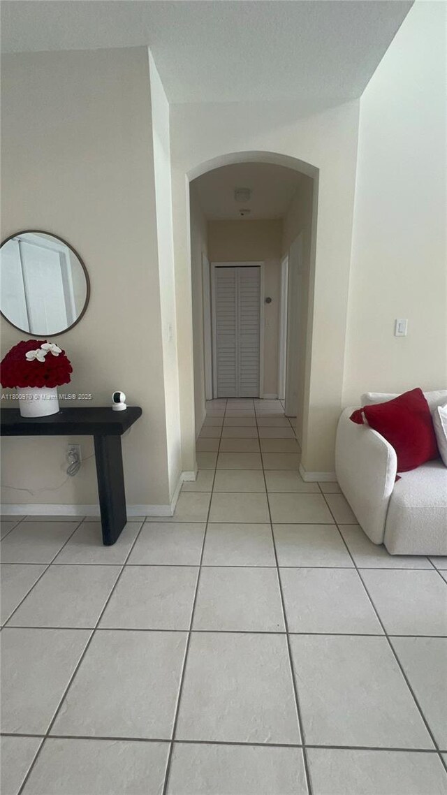 9942 SW 158th Ct, Miami, FL 33196 - hallway with arched walkways, light tile patterned flooring, and baseboards