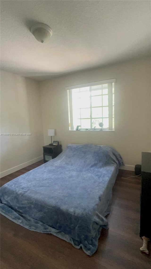 9942 SW 158th Ct, Miami, FL 33196 - bedroom with baseboards and dark wood-style flooring
