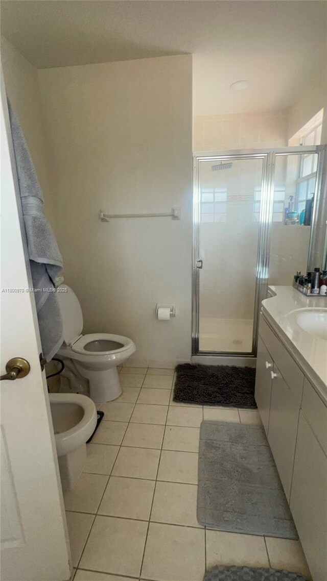 9942 SW 158th Ct, Miami, FL 33196 - bathroom with tile patterned floors, toilet, a shower stall, vanity, and a bidet