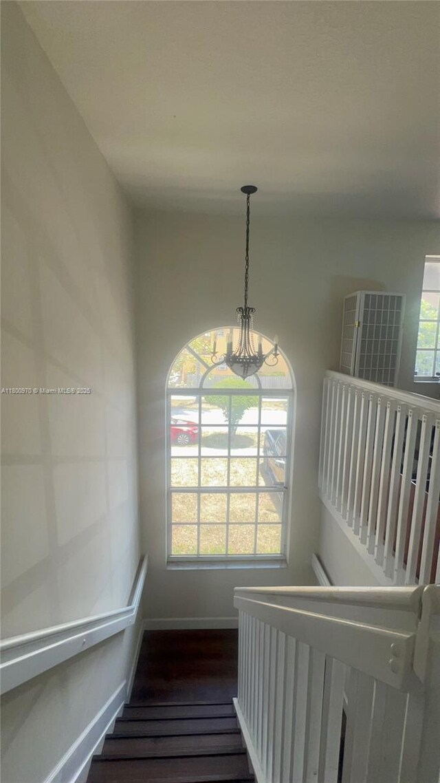 9942 SW 158th Ct, Miami, FL 33196 - stairway featuring a chandelier, baseboards, and wood finished floors