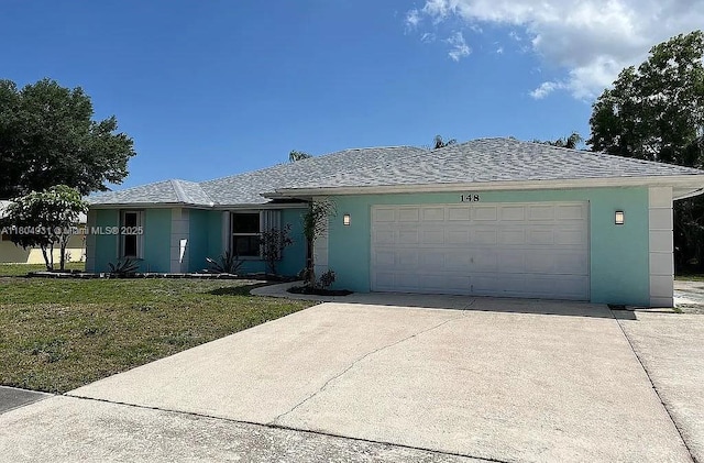148 SE Selva Ct, Port St Lucie, FL 34983 - ranch-style home featuring stucco siding, concrete driveway, a garage, and a front lawn