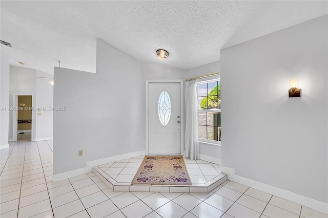 9828 SW 58th Ct, Cooper City, FL 33328 - foyer entrance featuring a textured ceiling, light tile patterned flooring, and baseboards