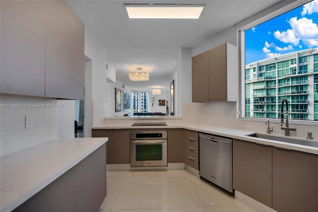 3030 NE 188th St Unit 602, Aventura, FL 33180 - kitchen featuring appliances with stainless steel finishes, modern cabinets, a sink, and gray cabinetry