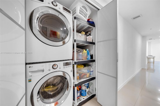 3030 NE 188th St Unit 602, Aventura, FL 33180 - laundry room featuring estacked washer and dryer, tile patterned floors, and baseboards