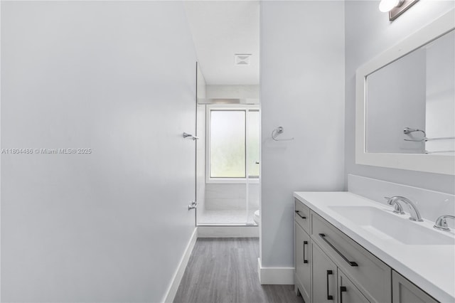 3639 NW 83rd Ln, Sunrise, FL 33351 - bathroom with baseboards, vanity, a stall shower, wood finished floors, and toilet