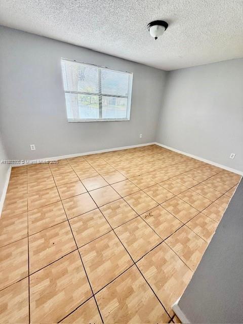 1100 Constitution Dr Unit 1100G, Homestead, FL 33034 - tiled spare room with a textured ceiling