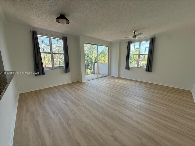 616 Clearwater Park Rd Unit 212, West Palm Beach, FL 33401 - unfurnished room featuring a textured ceiling, light wood-style flooring, a ceiling fan, and baseboards