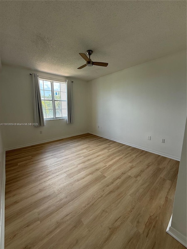 616 Clearwater Park Rd Unit 212, West Palm Beach, FL 33401 - spare room featuring a textured ceiling, a ceiling fan, light wood-style flooring, and baseboards