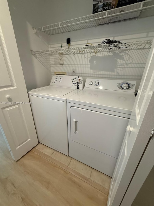 616 Clearwater Park Rd Unit 212, West Palm Beach, FL 33401 - washroom featuring washer and clothes dryer and light wood-style floors