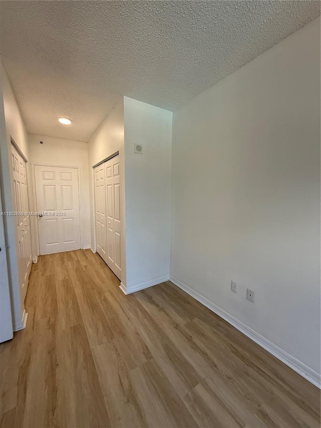 616 Clearwater Park Rd Unit 212, West Palm Beach, FL 33401 - unfurnished bedroom featuring baseboards, wood finished floors, a textured ceiling, and a closet