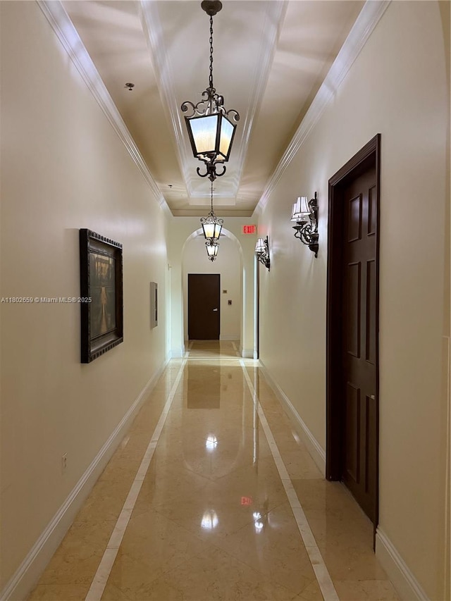 616 Clearwater Park Rd Unit 212, West Palm Beach, FL 33401 - hallway with inlaid floor details, a raised ceiling, arched walkways, baseboards, and crown molding