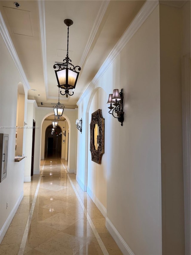 616 Clearwater Park Rd Unit 212, West Palm Beach, FL 33401 - hallway featuring inlaid floor details, arched walkways, a tray ceiling, baseboards, and crown molding