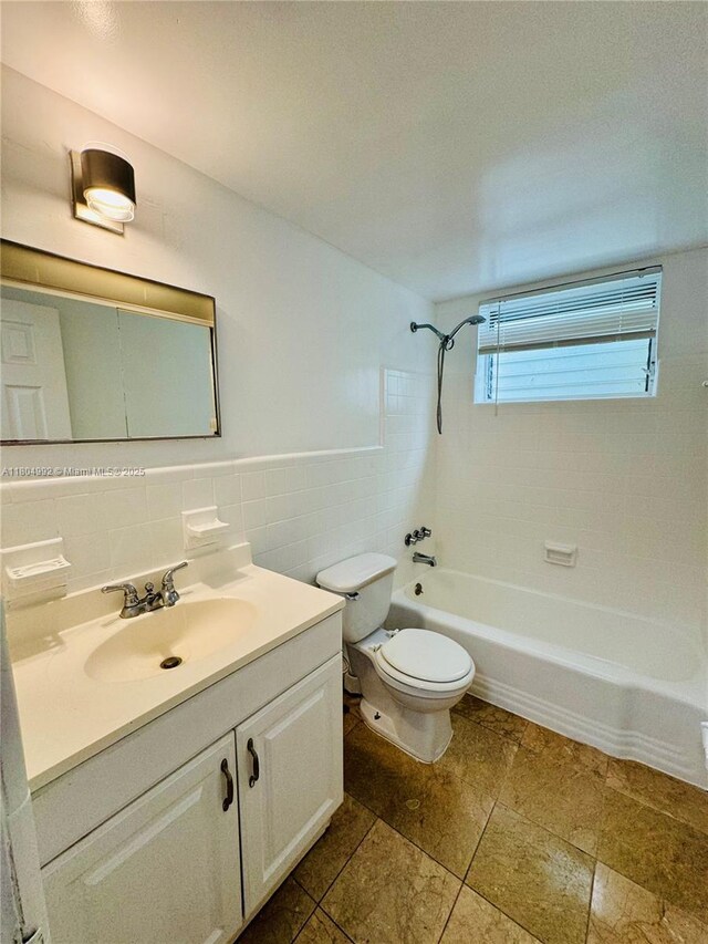 65 Washington Ave Unit 3, Miami Beach, FL 33139 - full bath with tile walls, toilet, bathing tub / shower combination, vanity, and a wainscoted wall