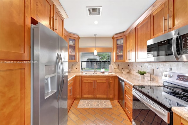 11955 Brim Way, Cooper City, FL 33026 - kitchen featuring stainless steel appliances, tasteful backsplash, brown cabinetry, and light stone countertops