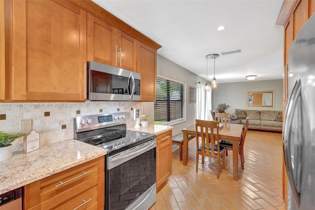 11955 Brim Way, Cooper City, FL 33026 - kitchen featuring appliances with stainless steel finishes, backsplash, light stone counters, brown cabinets, and open floor plan