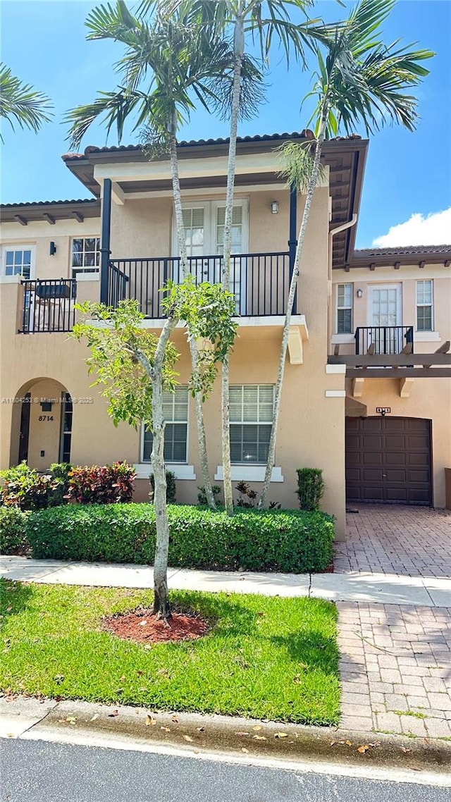 8716 Blaze Ct, Davie, FL 33328 - view of front of property featuring a garage, stucco siding, a balcony, and decorative driveway