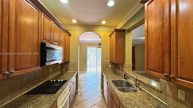 8716 Blaze Ct, Davie, FL 33328 - kitchen featuring stainless steel microwave, a sink, black electric cooktop, light tile patterned floors, and dark stone countertops