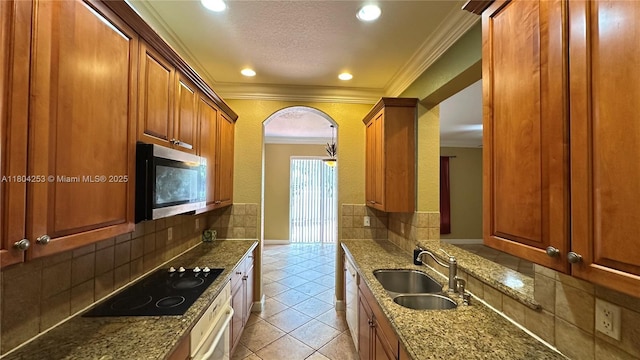 8716 Blaze Ct, Davie, FL 33328 - kitchen featuring stainless steel microwave, a sink, black electric stovetop, light tile patterned floors, and stone countertops