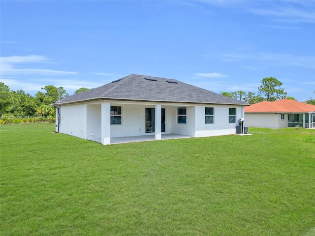 418 8th Ave, Lehigh Acres, FL 33972 - back of property featuring a patio area, a yard, stucco siding, and a shingled roof