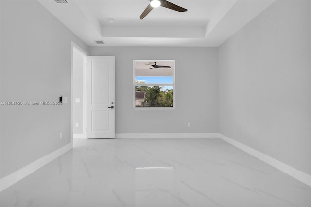 418 8th Ave, Lehigh Acres, FL 33972 - unfurnished room with marble tiled floors, a ceiling fan, a raised ceiling, and baseboards