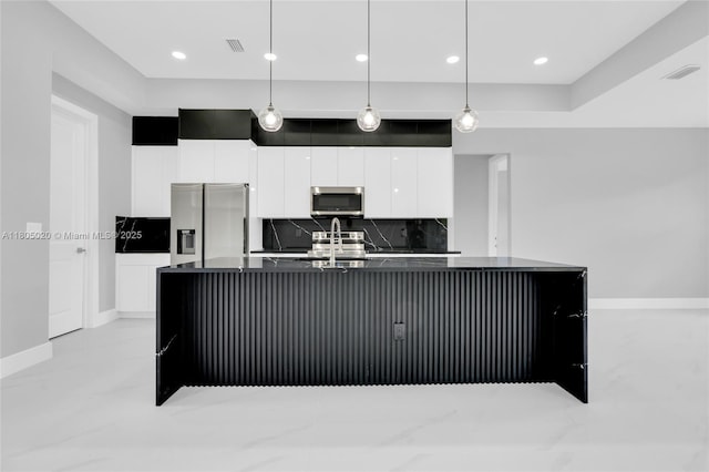 418 8th Ave, Lehigh Acres, FL 33972 - kitchen with appliances with stainless steel finishes, dark countertops, white cabinetry, an island with sink, and decorative backsplash