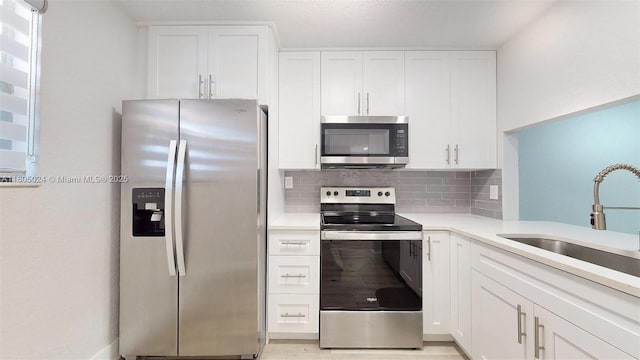 15805 W Waterside Cir Unit 202, Sunrise, FL 33326 - kitchen with appliances with stainless steel finishes, decorative backsplash, a sink, light countertops, and white cabinets
