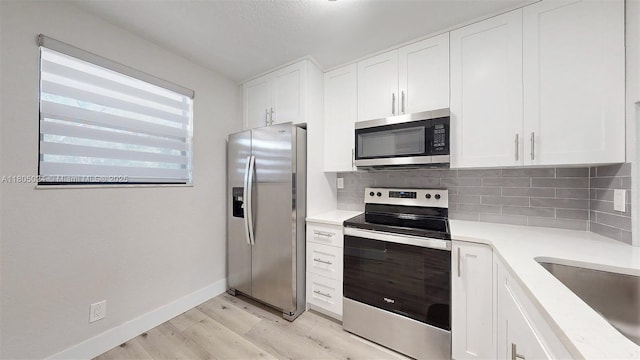 15805 W Waterside Cir Unit 202, Sunrise, FL 33326 - kitchen featuring stainless steel appliances, light wood-type flooring, tasteful backsplash, and white cabinets